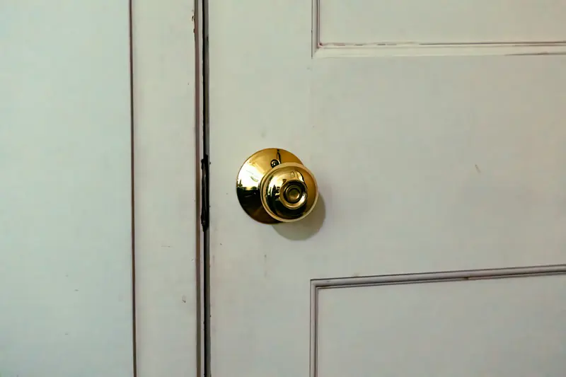 Maçaneta dourada em uma porta branca